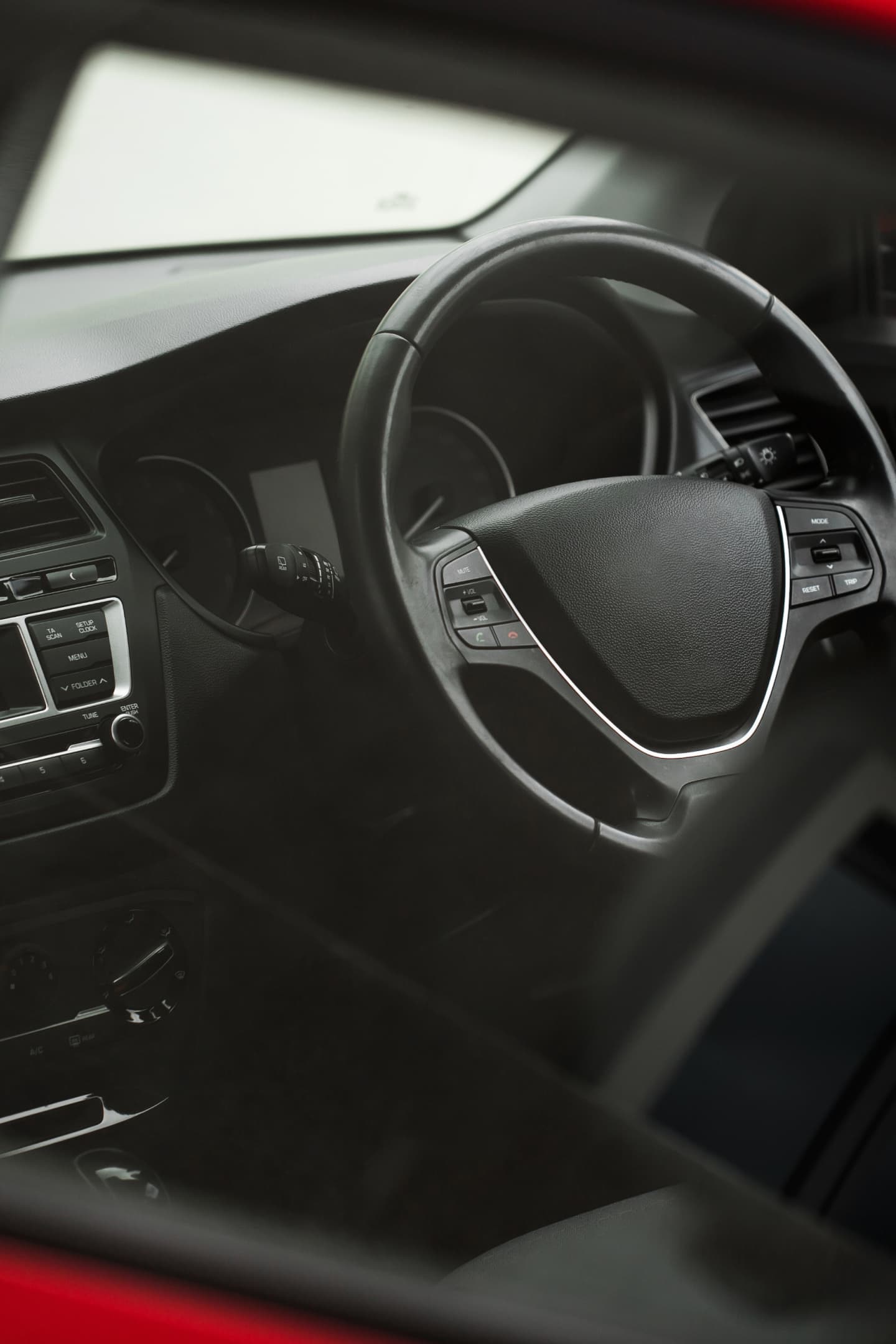 Image of a car interior focusing on the steering wheel Image of a car interior focusing on the steering wheel