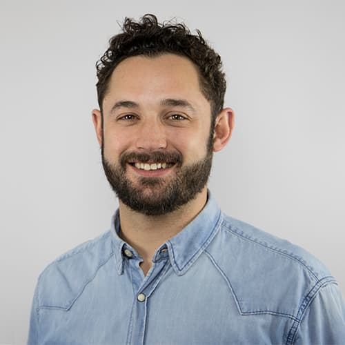 A picture of a man with curling hair, he is smiling. 