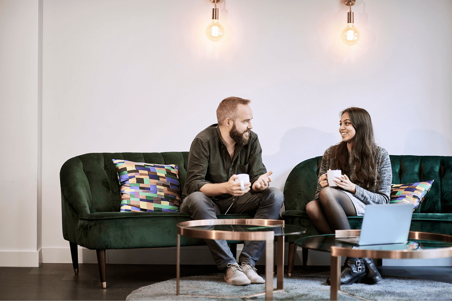Two people having a discussion in an office together with a cup of tea.  Two people having a discussion in an office together with a cup of tea.